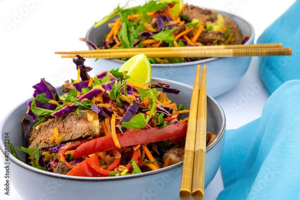 Fototapeta Tossed salad with steak strips and chop sticks