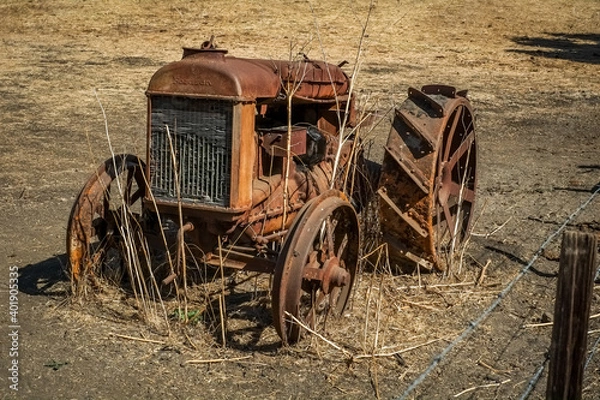 Obraz Historic Vintage rusty tractor in open hay field