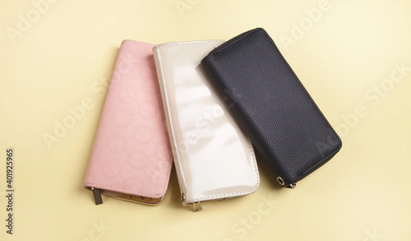 Obraz Womans wallets on an isolated yellow background.