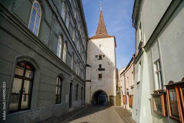 Obraz Gothic tower of the Velvary Gate, town fortifications built in the pre-Hussite period in sunny day, street of historic medieval city Slany, Central Bohemia, Czech Republic