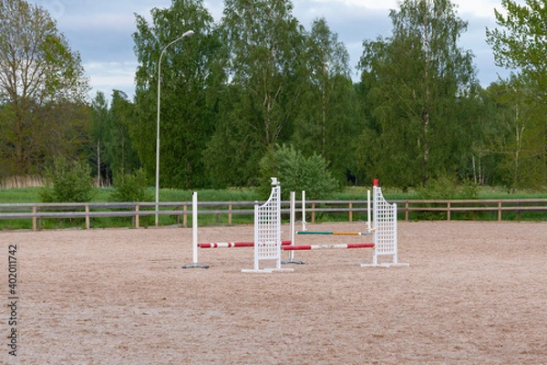 Obraz Wooden barriers, equestrian obstacles, barriers on the sand ground for jumping horses and riders at riding school