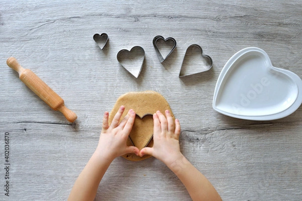 Obraz DIY making gingerbread by kid for Valentine's Day for parents. Baking training for children from 4 to 14 years old. early child development of fine motor skills. step by step. step 2