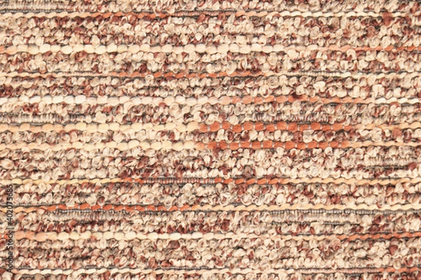 Fototapeta Beige-orange fabric sample with textured bouclé weave. Textiles and wool. Blank background and close-up.