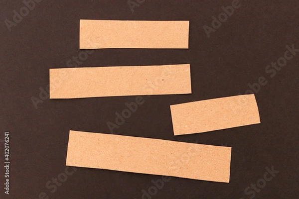 Fototapeta Blank craft cardboard strips for text on a black background.