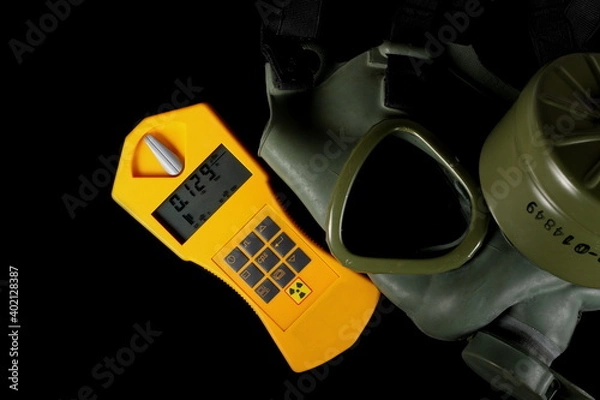 Fototapeta Military gas mask with Geiger counter, radiation detection device isolated on black background with clipping path, top view