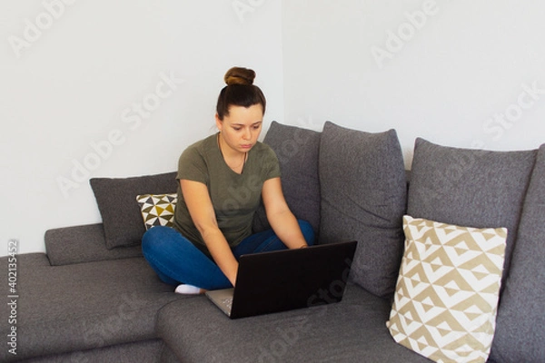 Fototapeta Girl at home working on the computer