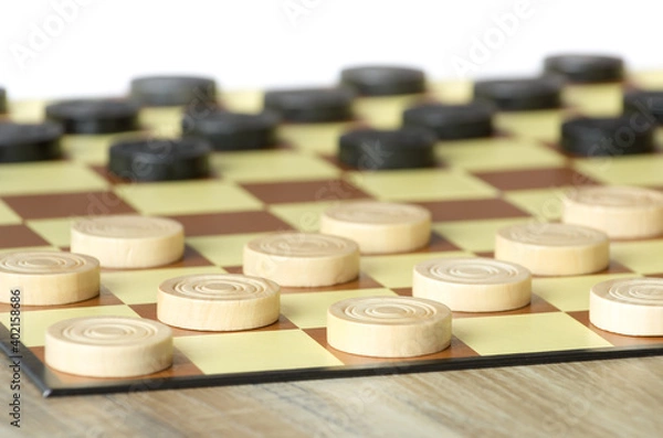 Fototapeta checkers or draughts is a board game. Close Up of wooden round checkers. white background with space for text