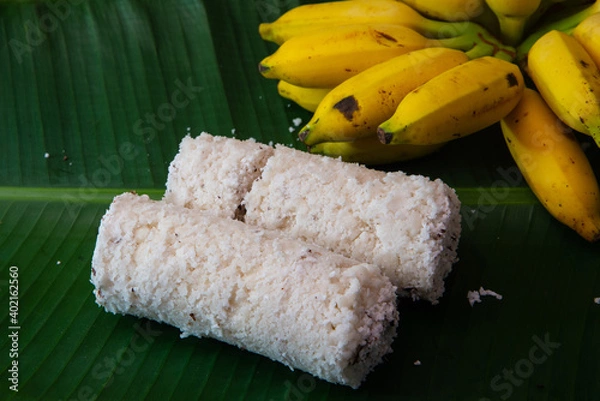 Obraz Popular Steamed Kerala Breakfast Dish served in banana leaf with yellow banana, puttu and yellow small banana served in banana leaf