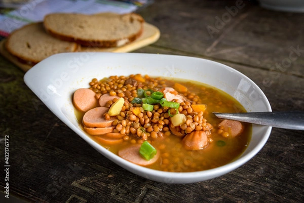 Fototapeta Linsensuppe mit Würstchen und Brot