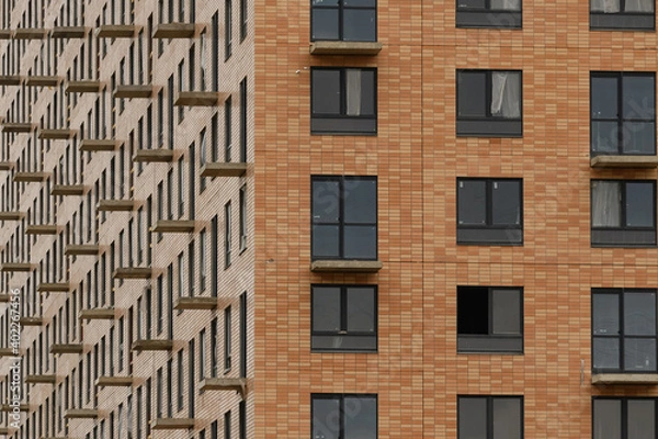 Fototapeta Facade with windows of an unfinished building, closeup house