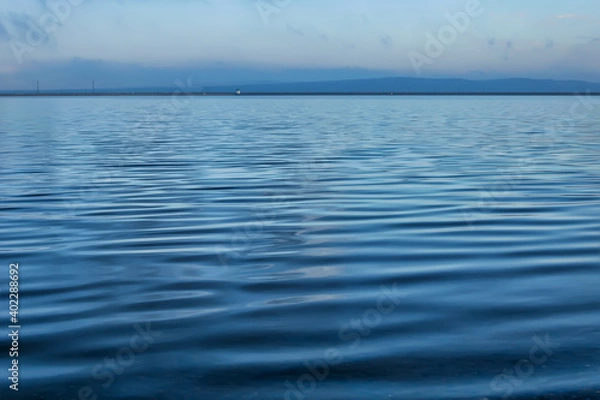 Fototapeta blue sky and water. a surface of a water or river that looks like a satin fabric texture