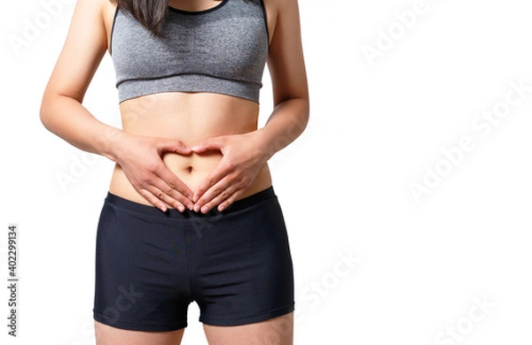 Fototapeta A young woman folded her hands in the shape of a heart on a naked belly. isolated on a white background.