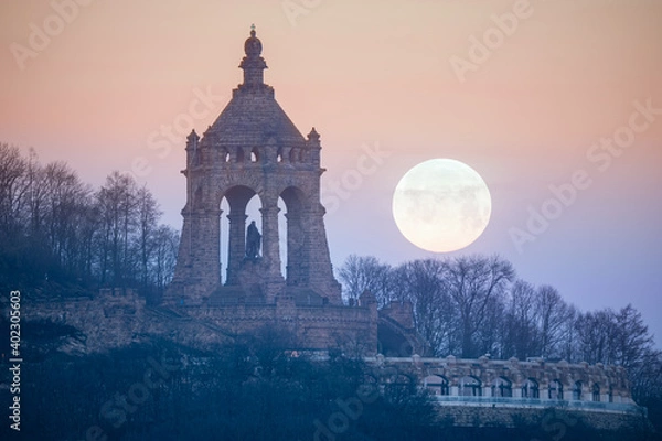 Fototapeta The moon setting behind the Kaiser Wilhelm Monument in Porta Westfalica