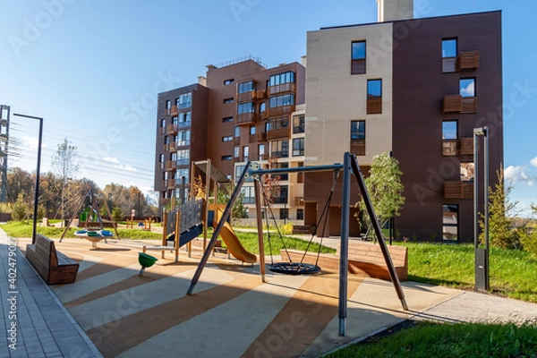 Fototapeta Modern house building with kids playground mixed-use urban multi-family residential district area development