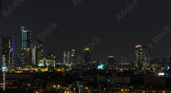 Fototapeta The high angle background of the city view with the secret light of the evening, blurring of night lights, showing the distribution of condominiums, dense homes in the capital community