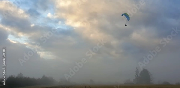 Fototapeta Paraglider on a misty day over a dramatic sky