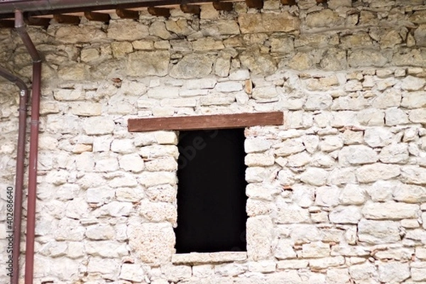Fototapeta A window with a wooden lintel of an abandoned ruined building (Marche, Italy, Europe)