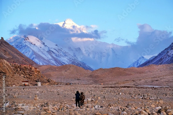 Fototapeta Tourists admiring Mount Everest at the Everest Base Camp in Tibet, against a blue sky covered by white clouds.