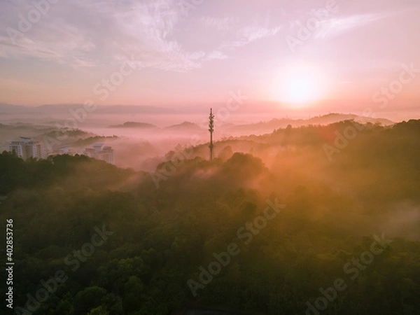 Fototapeta Aerial view of 5G Communication tower during morning sunrise with clouds, mists and fog