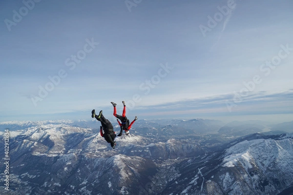 Fototapeta Skydivers perform stunts over Swiss Alps