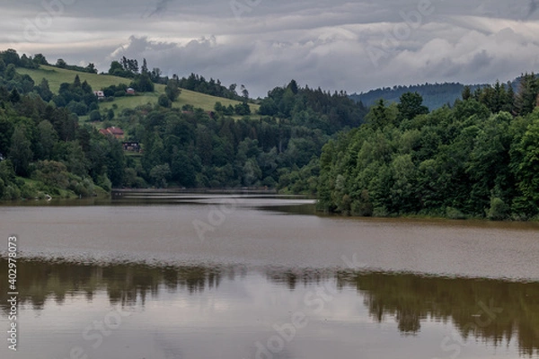 Fototapeta Water level of the Bystricka reservoir during a rainy afternoon with dark clouds in the sky.