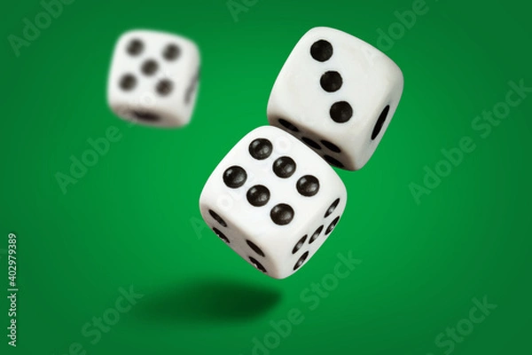 Fototapeta  White playing dice cubes in motion on the green surface, selective focus