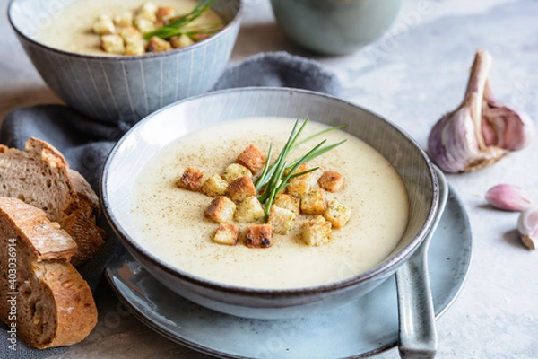 Fototapeta Creamy garlic soup topped with croutons and chives