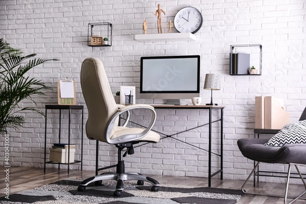Fototapeta Comfortable chair near desk in modern office interior