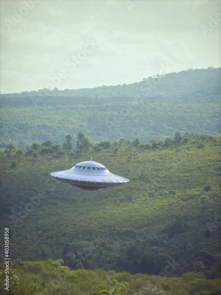 Obraz UFO, unidentified flying object, gravitating over the forest and mountain ranges. Clipping path included.