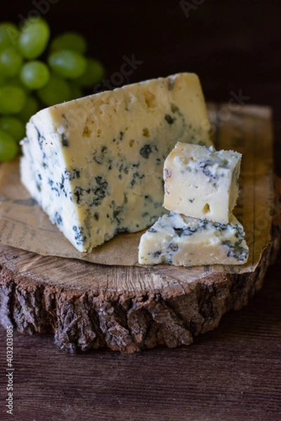 Fototapeta 
blue cheese on a wooden frame on a wooden background with white grapes in rustic style