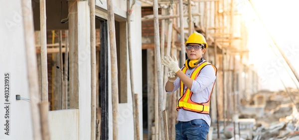 Fototapeta Attractive Asian engineer working on construction site. construction worker concept.