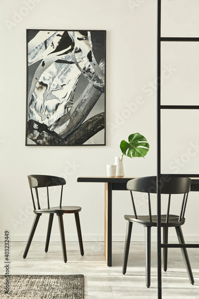 Fototapeta Stylish open space interior with wooden family table, black chairs, cups of coffee,  tropical leaf in vase, abstract painitings on the wall and elegant accessories. Modern home decor. Template.