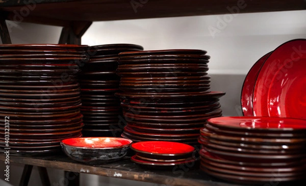 Fototapeta Stacks of craft ceramic or pottery plates on a shelf