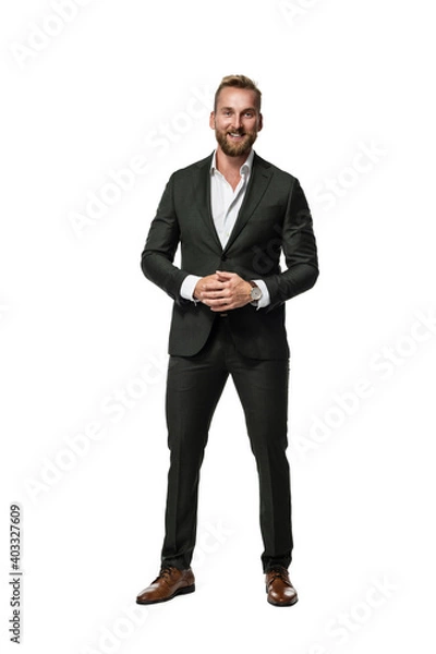 Fototapeta Handsome laughing businessman wearing a suit and shirt standing with his hands clasped. White background.