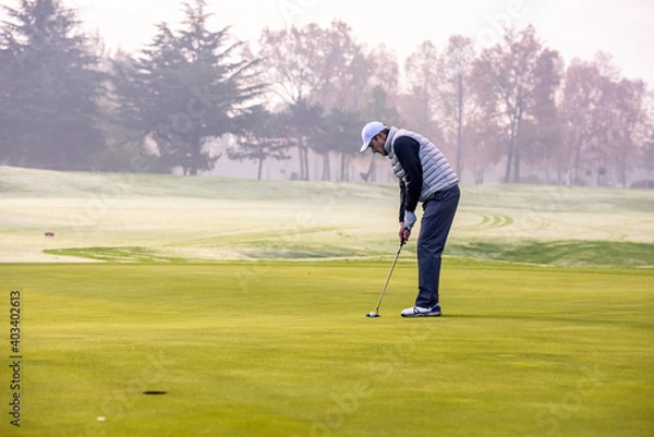 Obraz Golfer playing golf on the golf course during a winter day