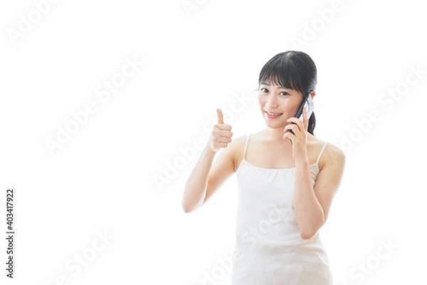 Obraz スマホで通話をする若い女性
