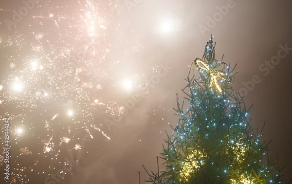 Obraz Decorated Christmas tree and fireworks in the sky.