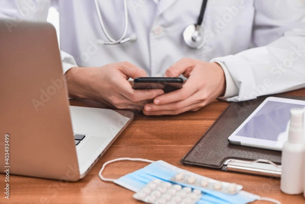 Fototapeta Physician using a phone to communicate with a patient
