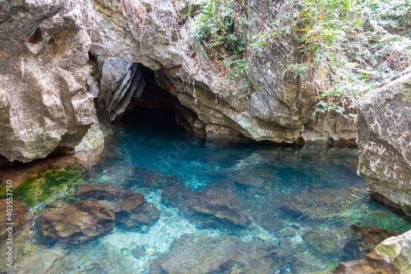 Obraz Cave in the water. A crystal clear water seeing through all the rocks on the floor.