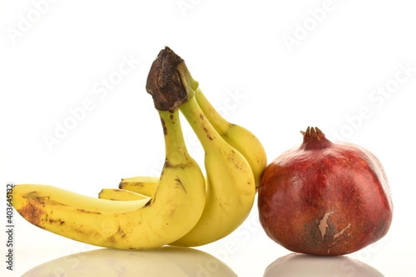 Fototapeta Fresh fruits - three bananas and one pomegranate, close-up, isolated on white.