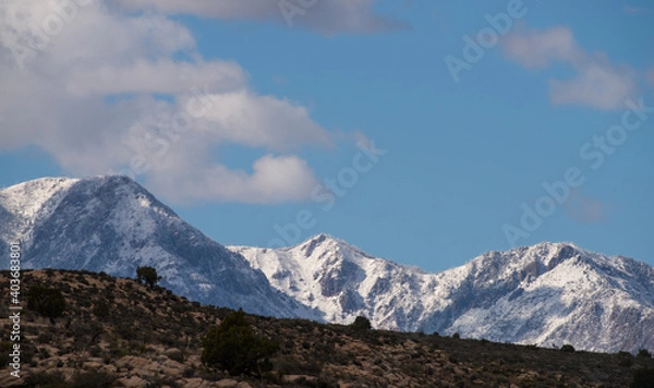 Fototapeta Snowy mountains above the dry desert wilderness, Southern Utah
