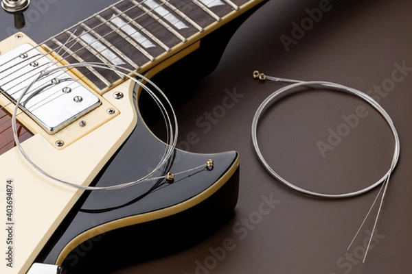 Fototapeta new music strings for electric guitar on a brown background. studio shot. space. restring concept. preparation to performance