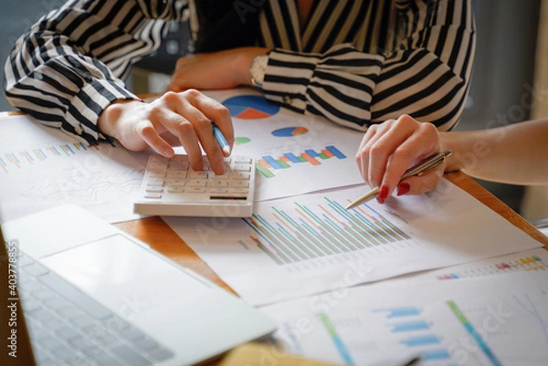 Obraz Close up of businesswoman working on calculator to calculate business data the financial report in meeting room. Business financial analysis and strategy concept.