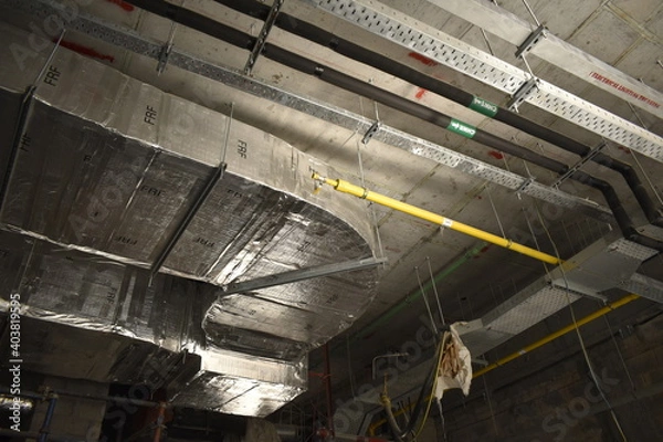 Fototapeta MEP works in civil construction site. Aluminum fabricated air flow duct and steel tray supporting works. ducting work. duct Insulation. HVAC system in the construction site.