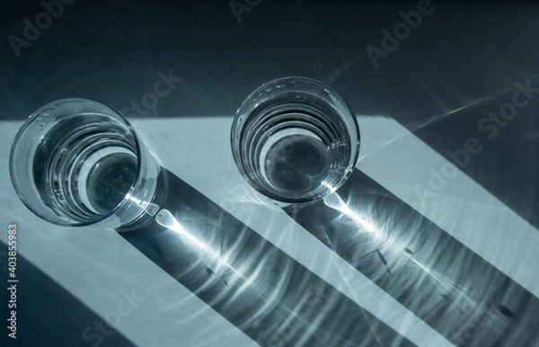 Obraz Two glasses of water. Shadow from glasses