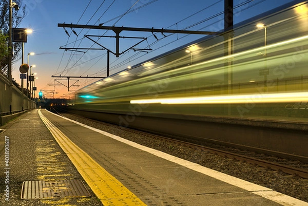 Fototapeta Spectacular view of railway station and colorful sky at Blackrock in the evening, Dublin, Ireland. Long exposure shot of the coming train