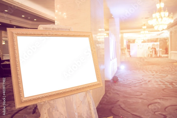 Fototapeta Blank Golden vintage photo frame at entrance wedding hall..Blank photo frame with copy space at hotel.Blank advertising billboard..Poster media template Ads display with copy space,