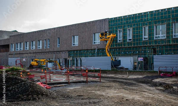 Obraz Vendée,France;7 janvier 2021:
chantier du futur lycée de Saint Gilles Croix de Vie pose de la façade en bois,un engin de chantier loué chez KILOUTOU,le pare-vapeur multivap 200 Ubbink encore visible.