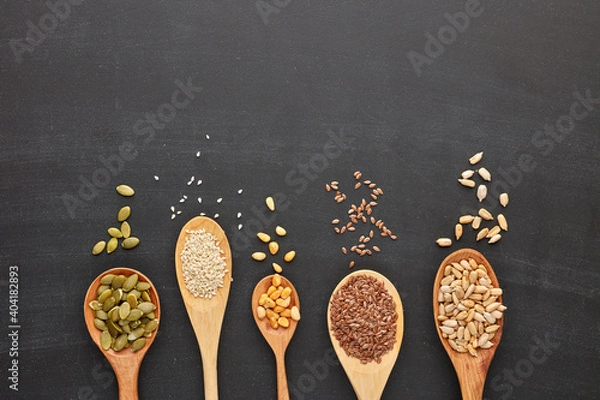 Obraz Different kinds of nuts and seeds on black slate background. Top view with copy space. Healthy food. Vegetarian nutrition