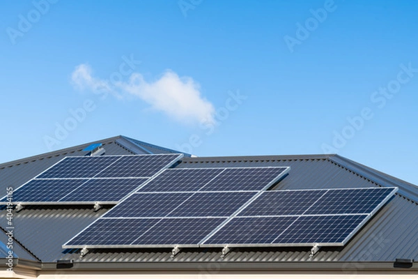 Fototapeta New solar panels installed on metal sheet roof of the house in South Australia against clear blue sky with a small cloud